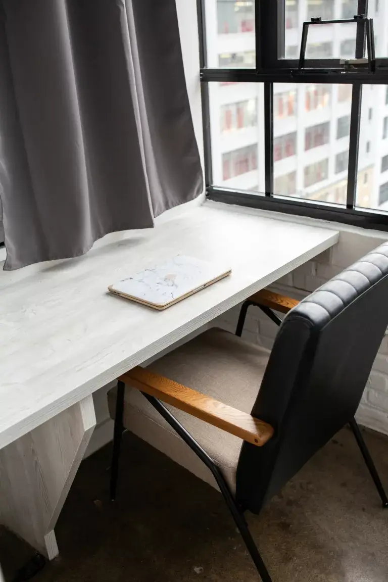Closed marble covered macbook on desk inside of an office