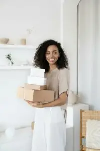 Woman holding boxes. joyful, happy, in home, curly hair